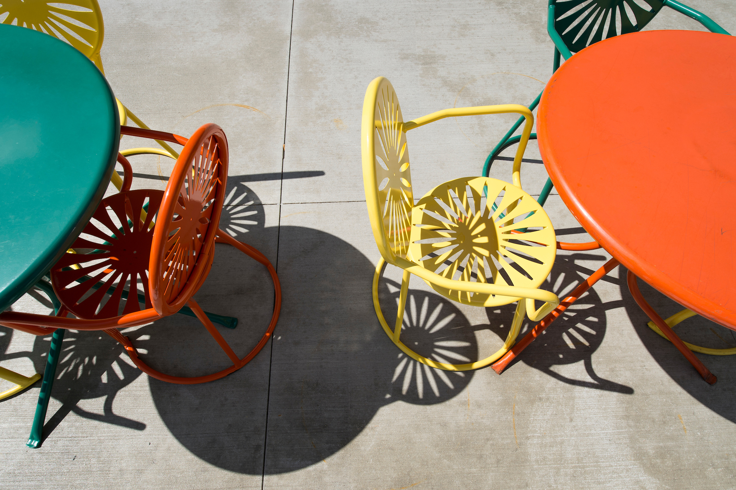 Shadows are cast from sun shining upon a group of Memorial Union Terrace chairs and tables at the University of Wisconsin-Madison during summer on July 1, 2014. The chairs are known for their iconic sunburst design. (Photo by Jeff Miller/UW-Madison)